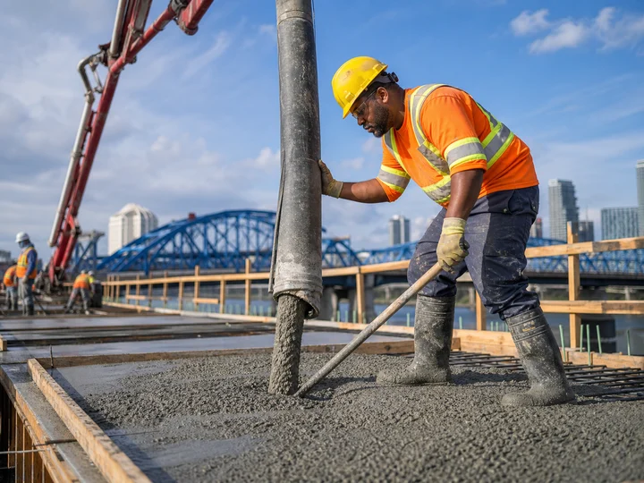 A construction labourer placing concrete on an active project.